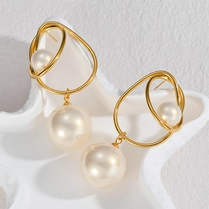 Boucles d'oreilles boucles dorées vintage avec perles sur plateau décoratif blanc