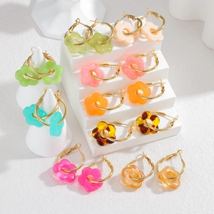 Gros plan de boucles d'oreilles fleur en résine colorée sur des supports de présentation