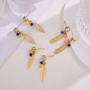 Detail of 14K gold feather earrings with colorful beads and sparkling rhinestones