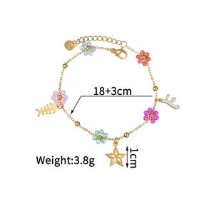 Détails d'un bracelet en acier doré avec perles de fleurs colorées et breloques variées