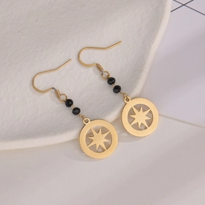 Detailed close-up of 14K gold plated star pendant earrings with black faceted beads