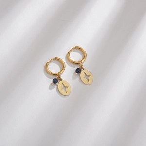 Detailed macro view of 14K gold plated hoop earrings with blue stone and star charms