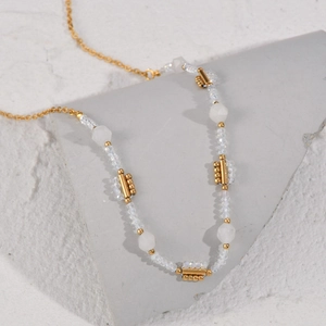 Detailansicht der bunten Perlenkette mit Goldkette auf geometrischem Steinständer