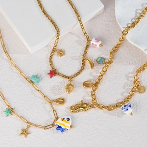 Détails de colliers dorés avec perles en céramique et pendentifs marins