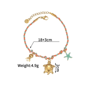 Macro detail of braided ocean theme bracelet with sea turtle, fish and starfish charms