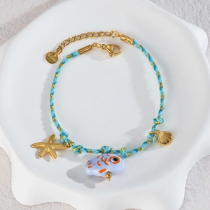 Handmade woven ocean bracelet with 18K gold star shell charms and blue fish pendant