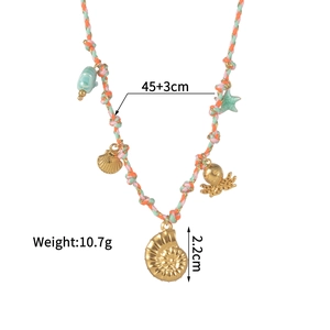 Détail du collier en cordon tressé coloré avec des breloques dorées de mer