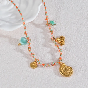 Détail du collier en corde tressée colorée avec des breloques dorées en forme de mer