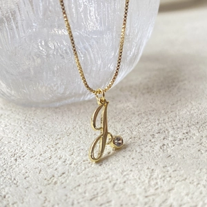 Detailed close-up of 14K gold plated J letter necklace with round cubic zirconia pendant