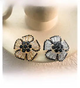 Detailed close-up of vintage flower earrings with baguette-cut clear and black zircons