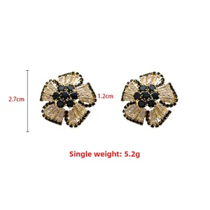 Detailed view of floral stud earrings with black and clear stones, dimensions 2.7cm by 1.2cm