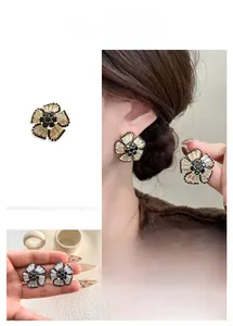 Macro shot of 3D floral stud earrings featuring contrast black and clear crystals