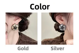 Detail of 3D flower stud earrings with black gemstone center in gold and silver finish