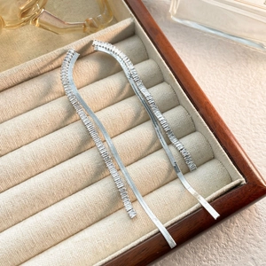 Detail view of silver long fringe earrings featuring square-cut zircons on velvet box