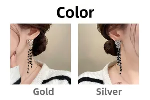 Detail of heart stud earrings with black crystal long tassels in gold and silver finish