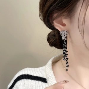 Detail of silver heart earrings with black bead tassels and sparkling cubic zirconia stones