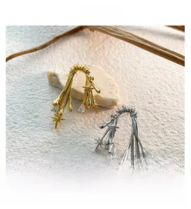 Detailed close-up of fluid lava-style earrings with gold and silver plating and zircons
