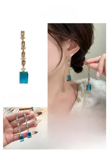 Dettagli di orecchini geometrici con cristallo blu, zircone rettangolare e placcati oro