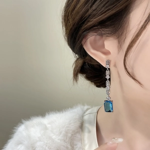 Dettaglio orecchino a pendente in argento con pietra blu e cristalli di zircone chiari