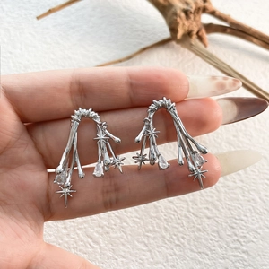 Detailed shot of thorn branch earrings with star charms and teardrop zircon accents