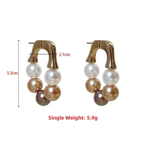 Détail de boucles d'oreilles en U dorées avec perles dégradées et dimensions de 3,2 cm