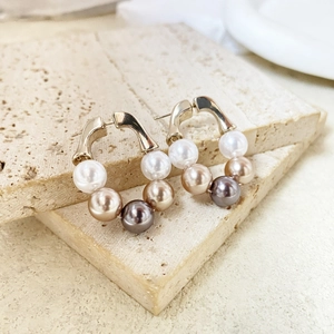 Boucles d'oreilles dorées en U avec des perles en dégradé blanc, champagne et gris