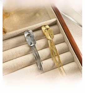 Detail of long metal tassel earrings in gold and silver finish on soft velvet padding