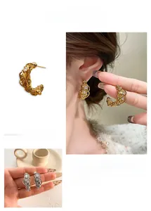 Dettaglio di orecchini a nido placcati oro 18k con zirconi su modella e mano