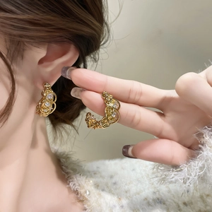 Orecchini a perno intrecciati placcati oro 18k con cristalli indossati da modella