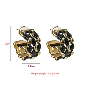 Detail showing 2cm x 1.1cm C-shaped quilted lattice earrings in black and gold