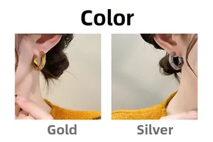 Detailed comparison of gold and silver textured C-shaped earrings on model ear