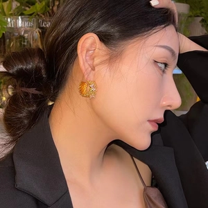 Geometric C-shaped gold hollow earrings with sparkling cubic zirconia on a female model