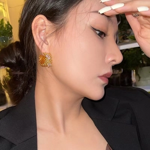 Luxe C-shaped hollow gold earrings with irregular lava texture and zircon stones on model