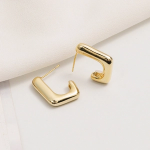 Vue macro de boucles d'oreilles en forme de U plaquées or avec finition miroir polie