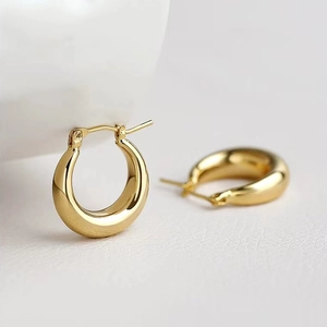 Klassieke dikke gouden oorringen met gepolijste afwerking op elegante witte achtergrond