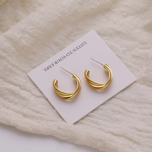 Three-layer twisted gold C-shaped hoop earrings with a matte vintage metallic finish