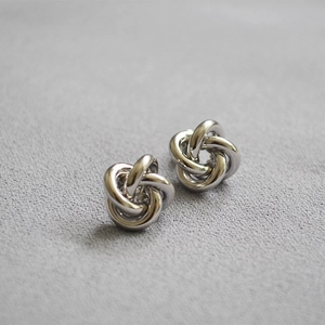 Minimalist silver metal knot earrings with polished multi-layered circular design