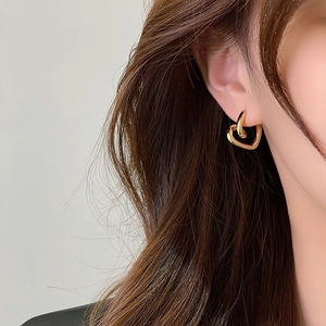 Elegant gold heart-shaped brass hoop earrings shown on a model for a stylish look