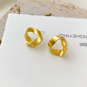 Matte gold French luxury twist earrings with minimalist hollow design on white display card