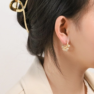 Elegant French gold hoop earrings with sparkling rhinestone spheres on female model