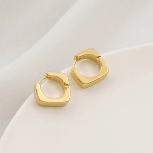 French vintage geometric square gold metal hoop earrings displayed on a white pedestal