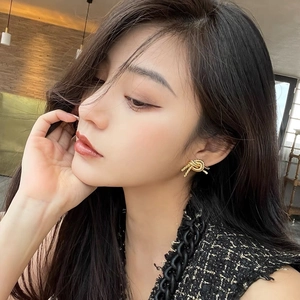 Elegant 14K gold brass knot stud earrings with a twisted rope design worn on ear