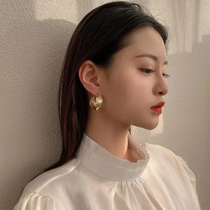 Golden chunky hoop earrings with spiral texture shown on a female model profile