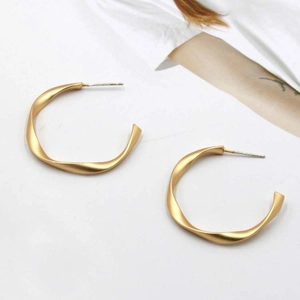 Classic golden twisted C-shaped stud earrings with a matte textured metal finish