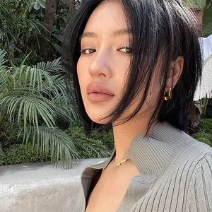 Minimalist geometric gold hoop earrings with polished finish worn by a model outdoors