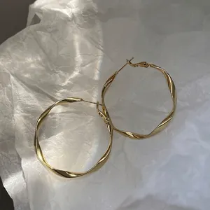 Elegant gold twisted hoop earrings with minimalist geometric design and 925 silver needles