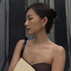 Minimalist geometric gold double hoop earrings shown on model with hair claw clip