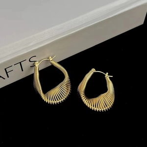 Elegant gold U-shaped earrings with fine wire wrap texture on a minimal black background