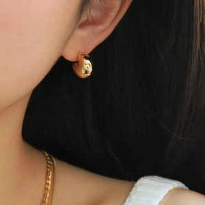 Elegant gold crescent moon earrings in polished finish worn by a model in a partial view