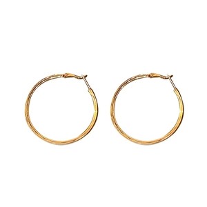 Minimalist large golden hoop earrings with high polish finish on a white background